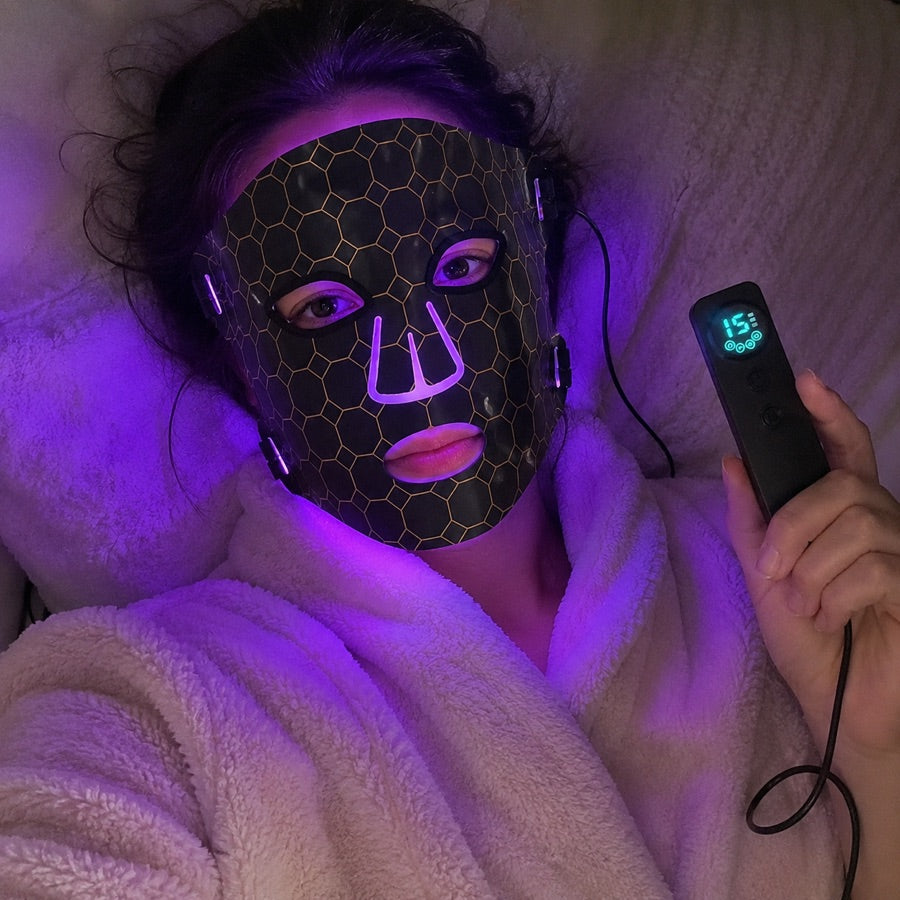 Woman resting under purple light with the LED FLEX Mask