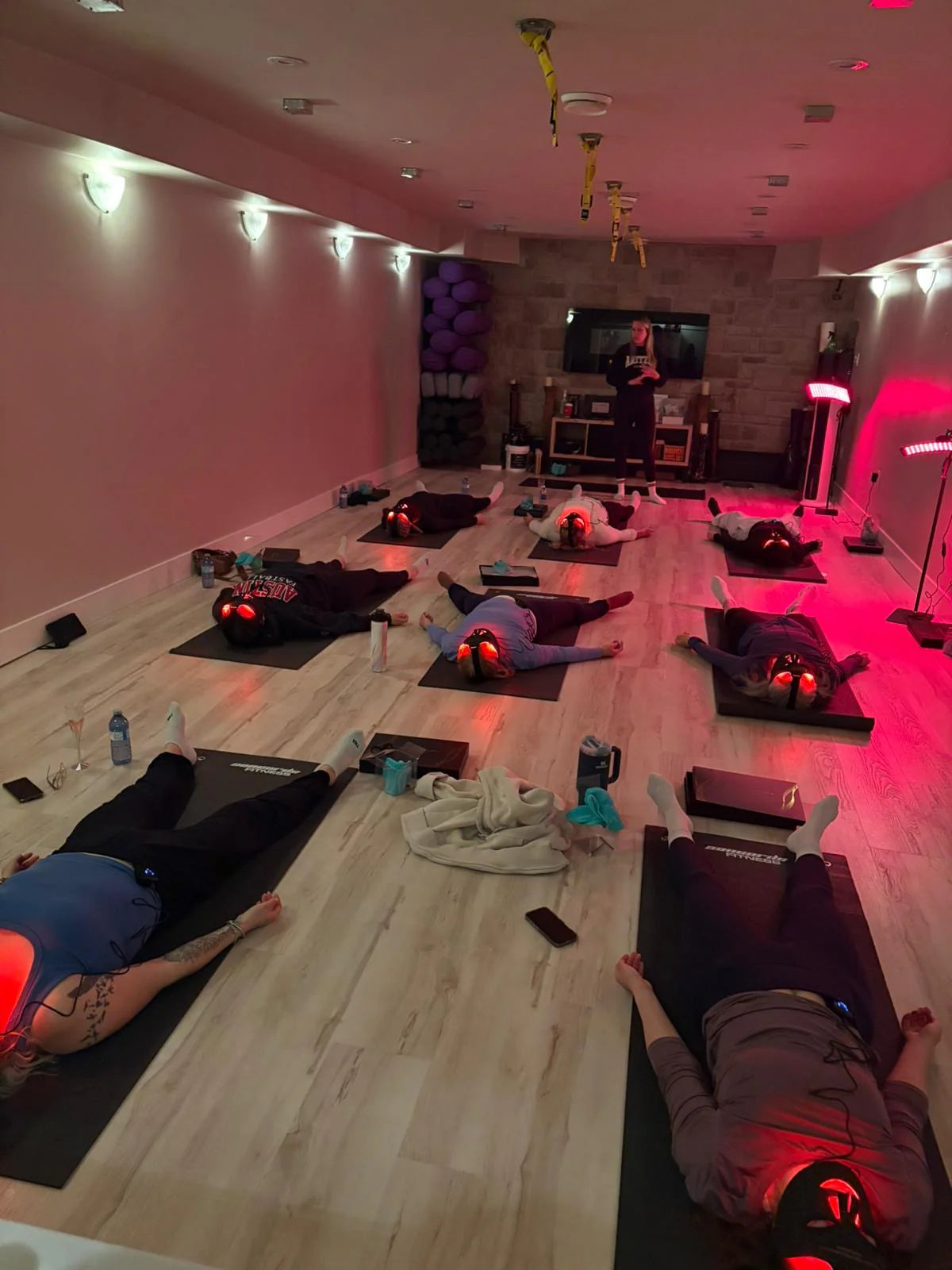 Guests resting under red light during a Wellness Route yoga event.