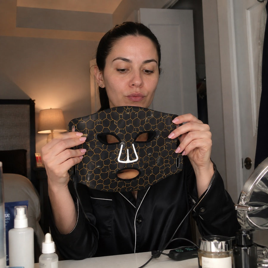 Woman preparing the LED FLEX Mask at her vanity