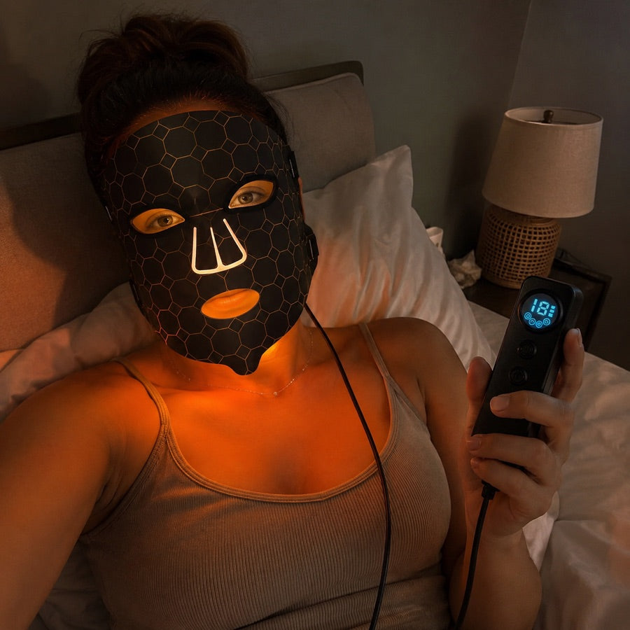 Woman using the amber LED FLEX Mask setting before bed
