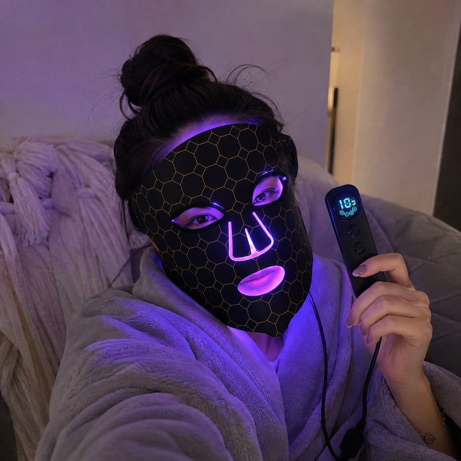 Woman relaxing on the couch with the purple LED FLEX Mask setting