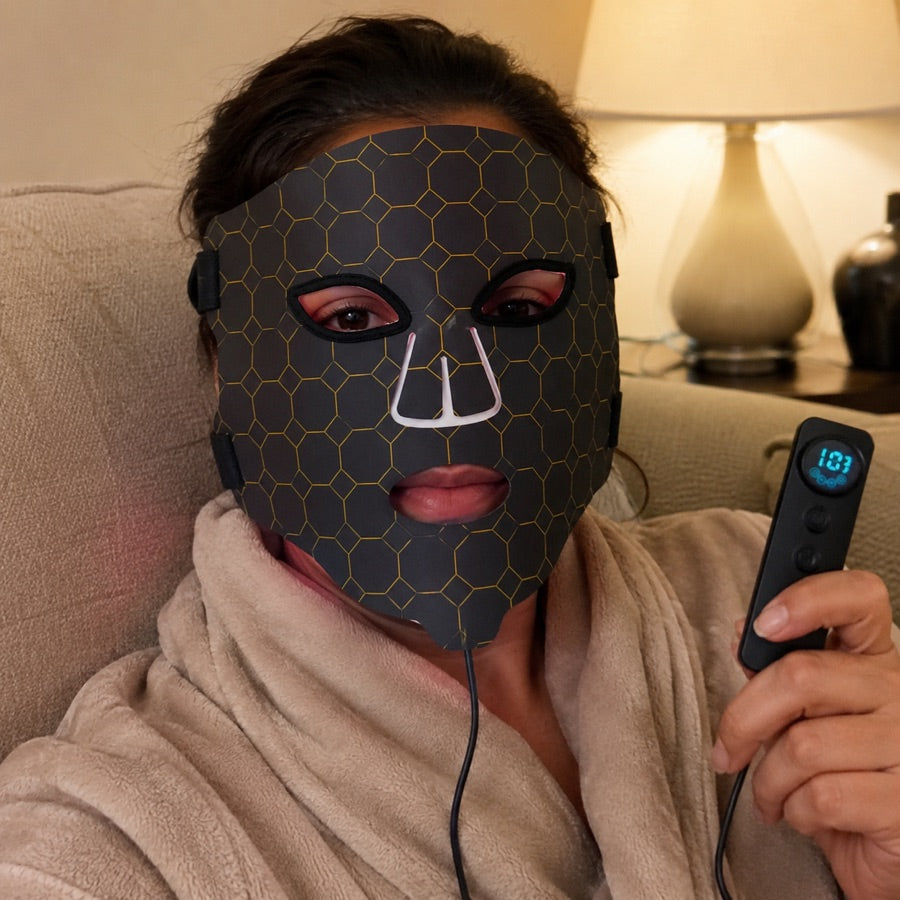 Woman unwinding in a robe with the LED FLEX Mask controller